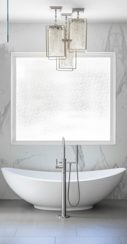 Пример оригинального дизайна: главная, серо-белая ванная комната среднего размера в стиле модернизм с плоскими фасадами, серыми фасадами, отдельно стоящей ванной, душем в нише, биде, белой плиткой, галечной плиткой, полом из керамогранита, врезной раковиной, столешницей из искусственного камня, серым полом, белой столешницей, зеркалом с подсветкой, тумбой под две раковины и встроенной тумбой