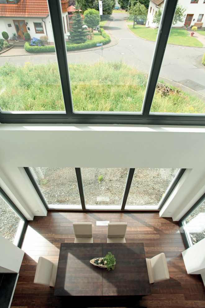 Moderner Wintergarten mit dunklem Holzboden, Kaminofen und braunem Boden in Sonstige