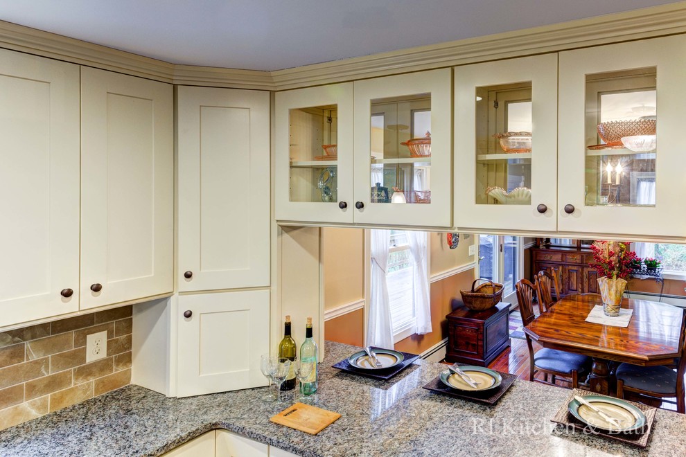 Inspiration for a large transitional u-shaped light wood floor eat-in kitchen remodel in Providence with an undermount sink, shaker cabinets, beige cabinets, granite countertops, brown backsplash, porcelain backsplash, stainless steel appliances and an island