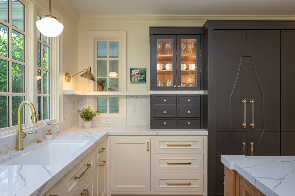 Example of a large classic u-shaped medium tone wood floor and brown floor enclosed kitchen design in Raleigh with an undermount sink, raised-panel cabinets, white cabinets, quartzite countertops, white backsplash, quartz backsplash, paneled appliances, an island and white countertops