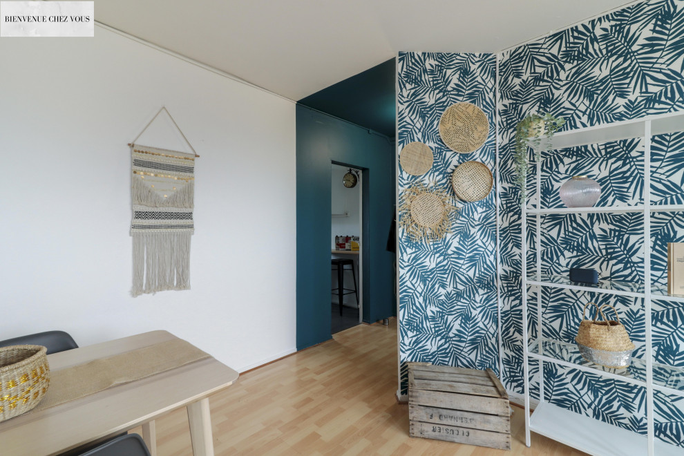 Foto på ett mellanstort tropiskt vardagsrum, med blå väggar, laminatgolv, en fristående TV och beiget golv