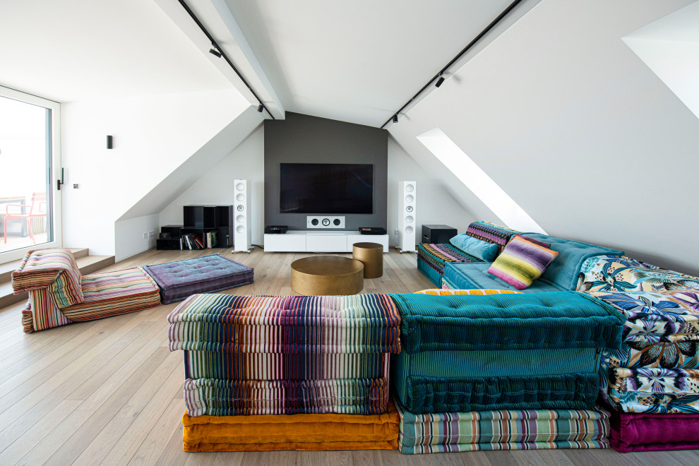 Foto de sala de estar abierta contemporánea grande con paredes blancas, suelo de madera en tonos medios, chimeneas suspendidas, televisor colgado en la pared y suelo marrón