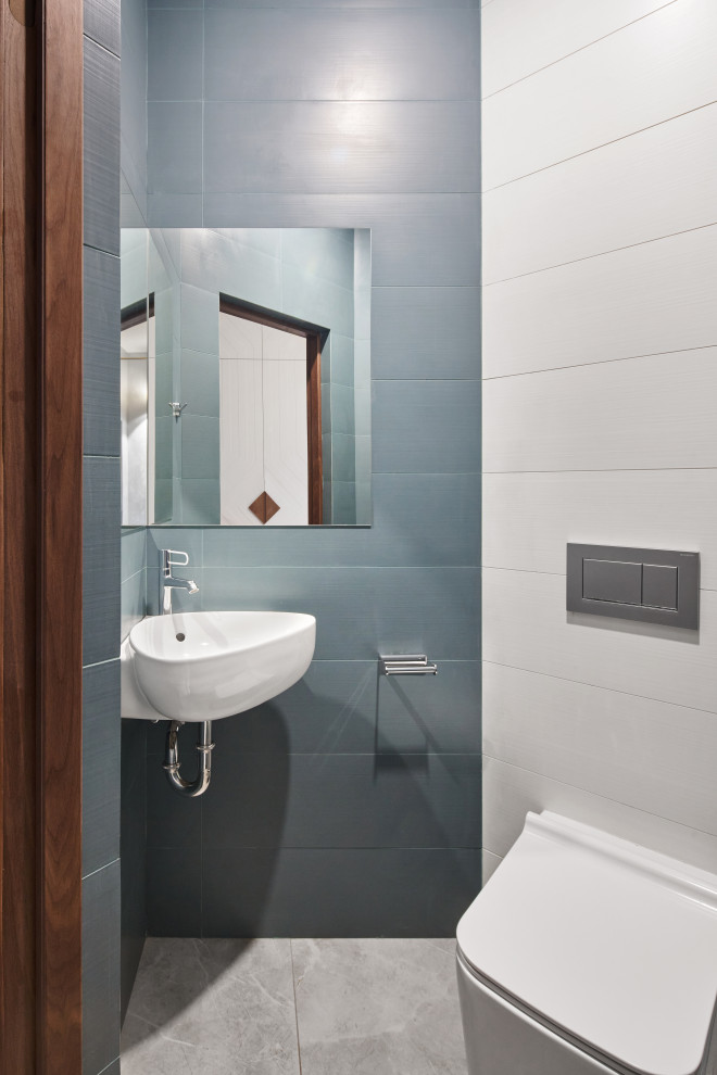 Immagine di un piccolo bagno di servizio design con WC sospeso, piastrelle blu, piastrelle in gres porcellanato, pareti grigie, pavimento in gres porcellanato, lavabo sospeso e pavimento grigio
