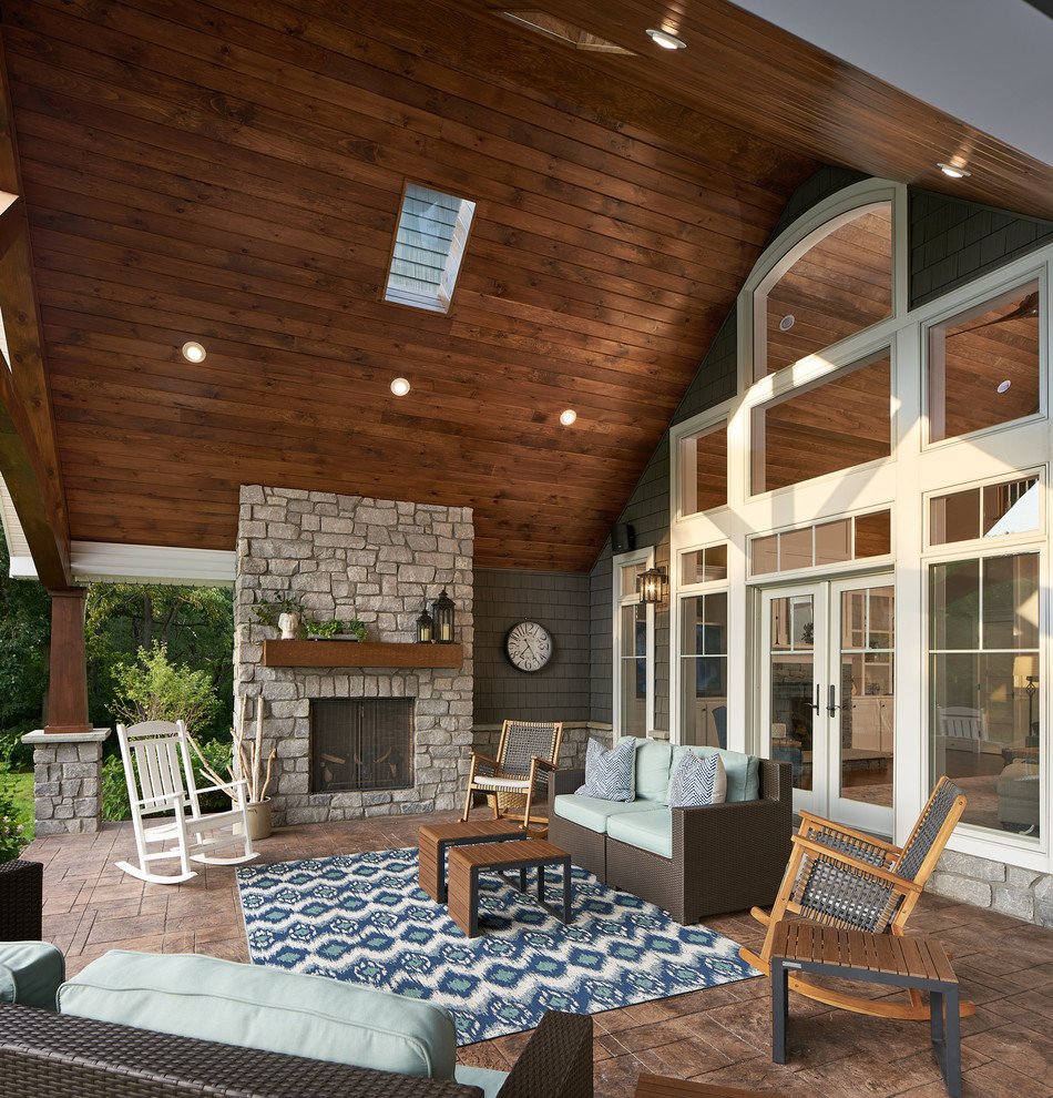 This is an example of a traditional verandah in New York with with fireplace, tile and a roof extension.