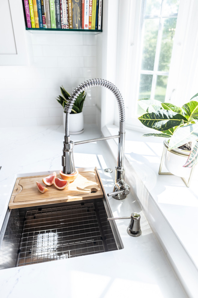 Eat-in kitchen - mid-sized transitional l-shaped light wood floor and brown floor eat-in kitchen idea in Baltimore with an undermount sink, shaker cabinets, white cabinets, quartz countertops, white backsplash, marble backsplash, stainless steel appliances, an island and white countertops