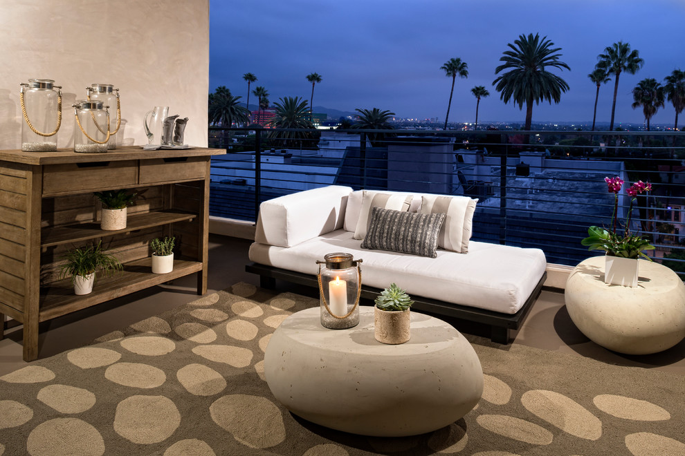 Mid-sized trendy backyard concrete paver patio photo in Los Angeles with a roof extension