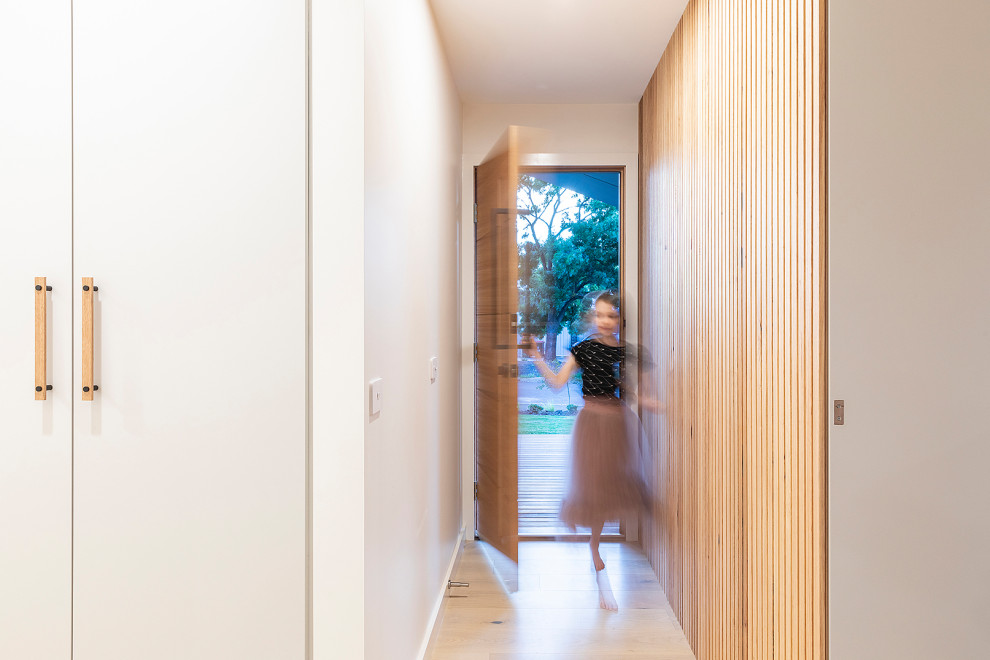 キャンベラにある高級な小さなコンテンポラリースタイルのおしゃれな玄関ドア (白い壁、淡色無垢フローリング、淡色木目調のドア) の写真