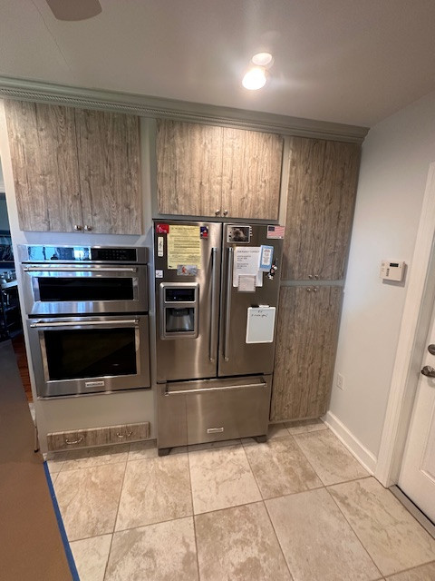 Eat-in kitchen - large l-shaped eat-in kitchen idea with an undermount sink, flat-panel cabinets, medium tone wood cabinets, stainless steel appliances and an island