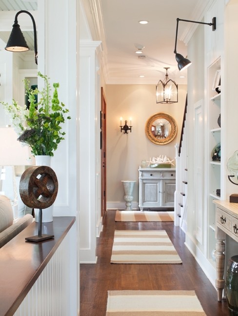 Photo of a mid-sized beach style hallway in New York with beige walls, dark hardwood floors and brown floor.