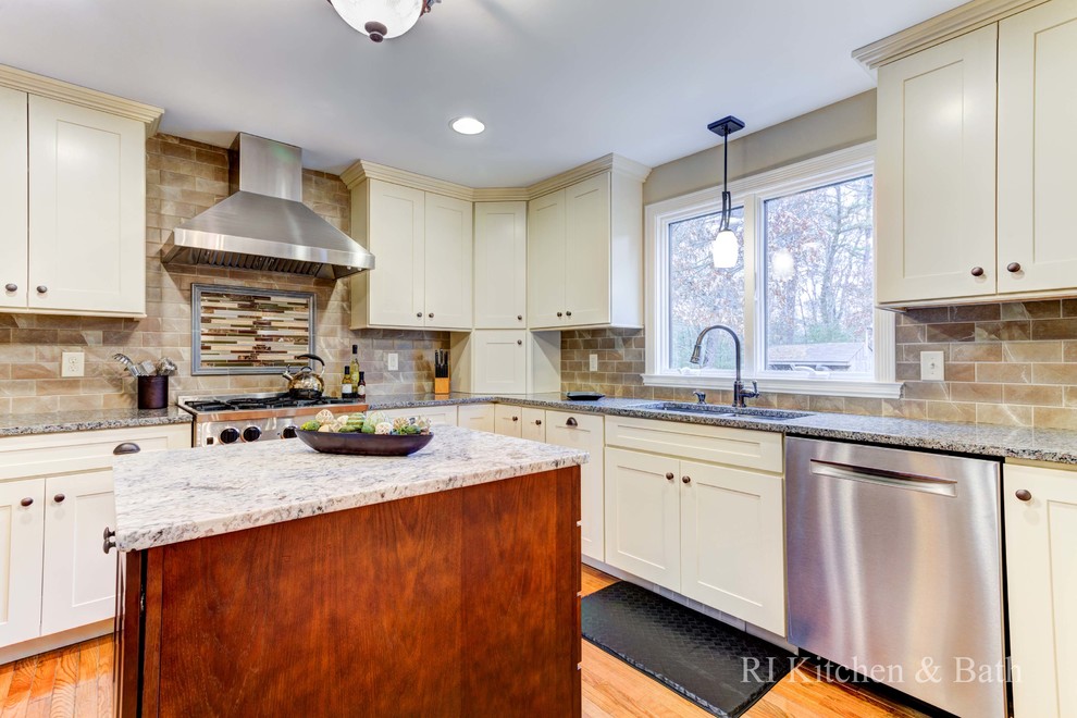 Eat-in kitchen - large transitional u-shaped light wood floor eat-in kitchen idea in Providence with an undermount sink, shaker cabinets, beige cabinets, granite countertops, brown backsplash, porcelain backsplash, stainless steel appliances and an island