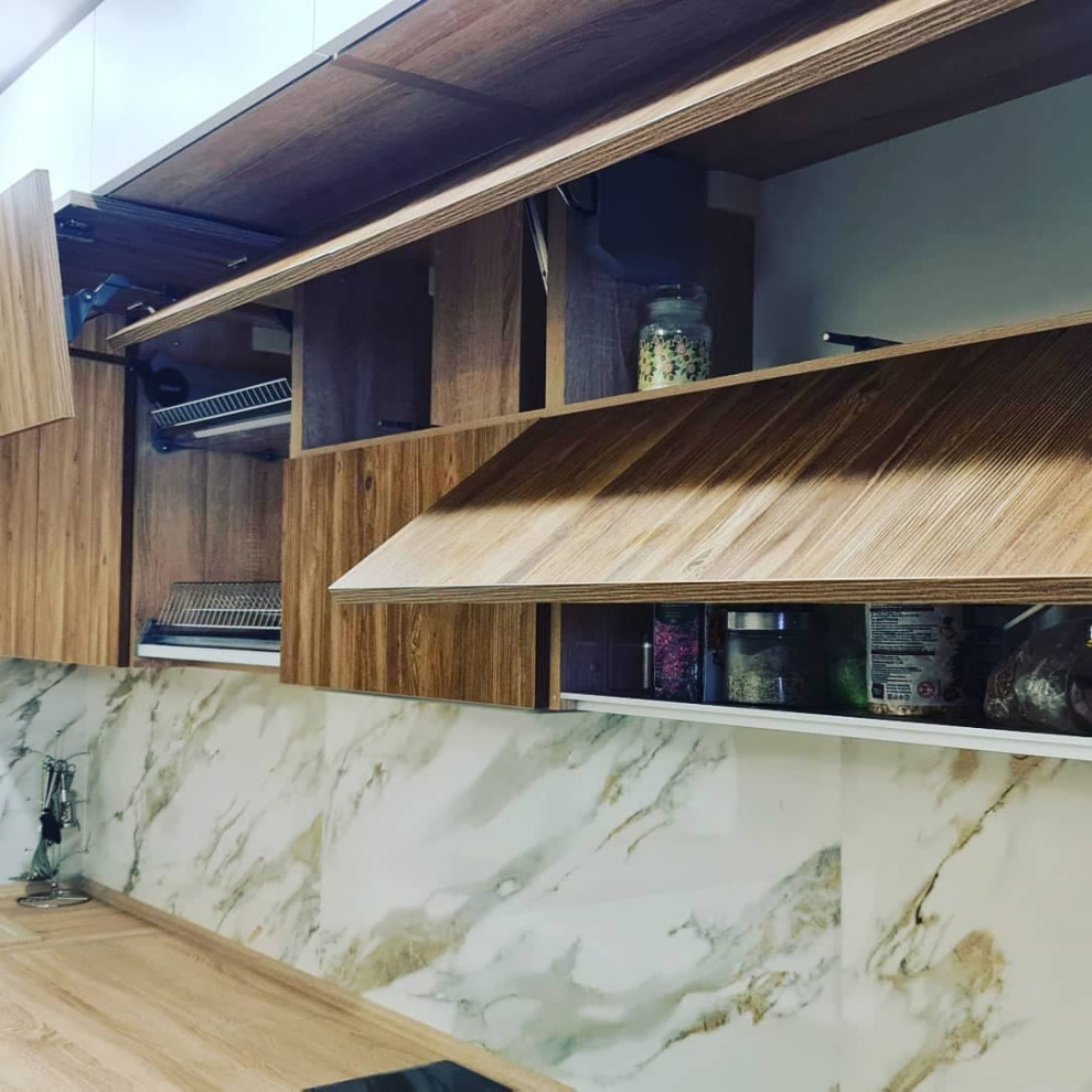 Photo of a mid-sized modern l-shaped eat-in kitchen in Moscow with a drop-in sink, raised-panel cabinets, white cabinets, wood benchtops, white splashback, granite splashback, panelled appliances, linoleum floors, no island, beige floor and brown benchtop.