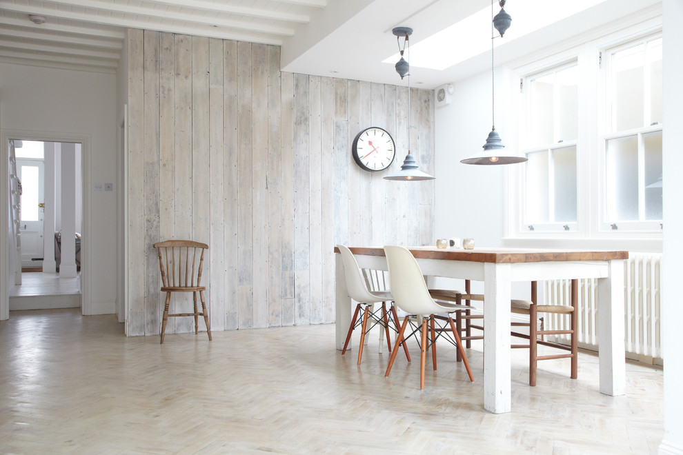 Inspiration for a scandinavian dining room in London with white walls, light hardwood floors and beige floor.