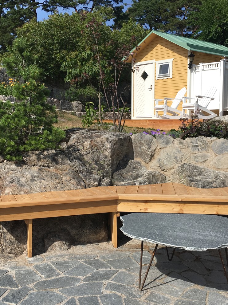 Photo of a beach style side yard partial sun garden for summer in Stockholm with natural stone pavers.