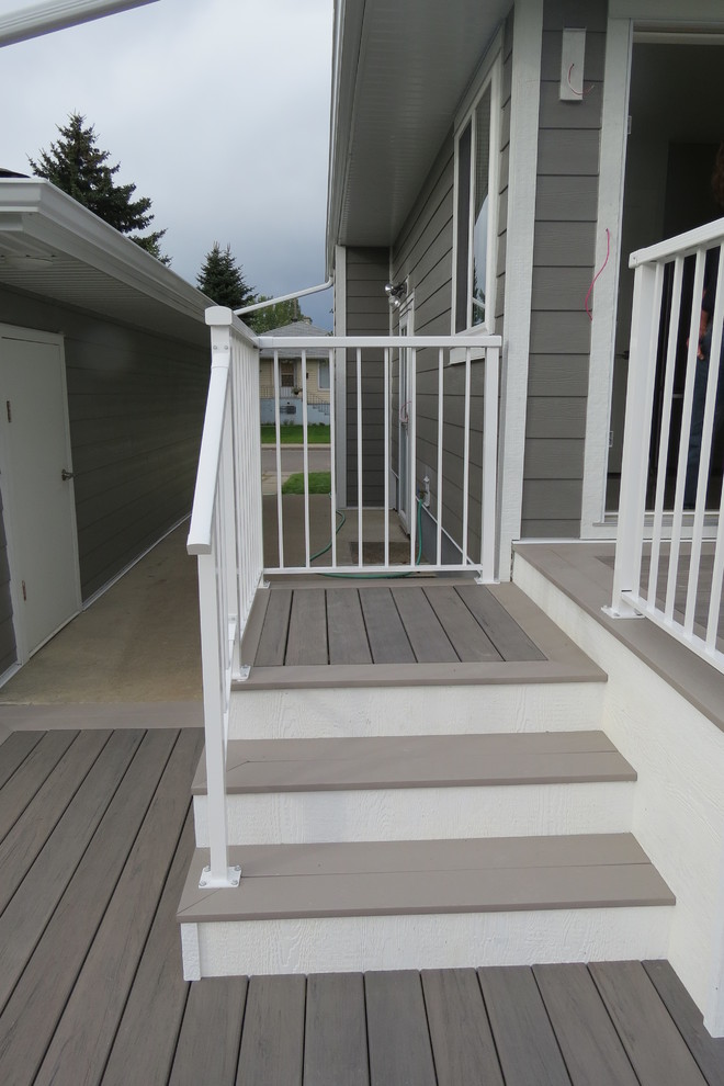 This is an example of a mid-sized traditional backyard deck in Calgary with no cover.