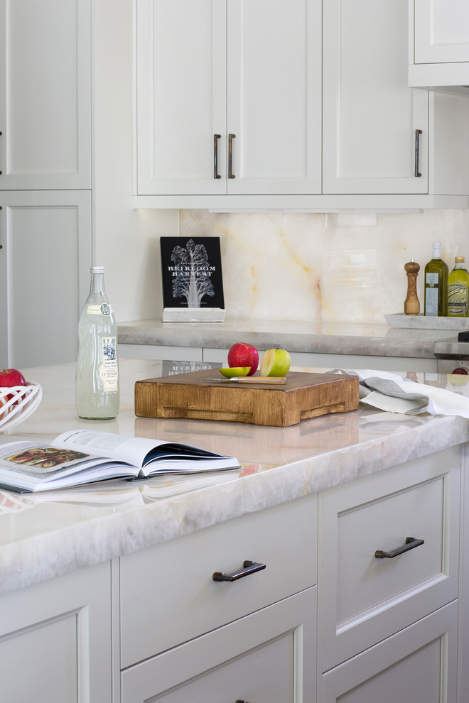 Inspiration for a mid-sized transitional l-shaped medium tone wood floor open concept kitchen remodel with a single-bowl sink, shaker cabinets, white cabinets, wood countertops, white backsplash, stone slab backsplash, paneled appliances and two islands