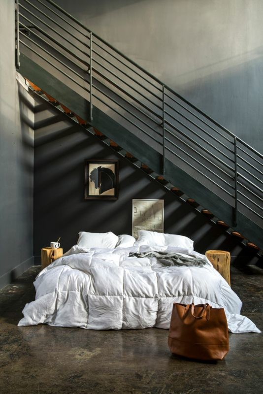 Mid-sized modern bedroom in New York with white walls and concrete floors.