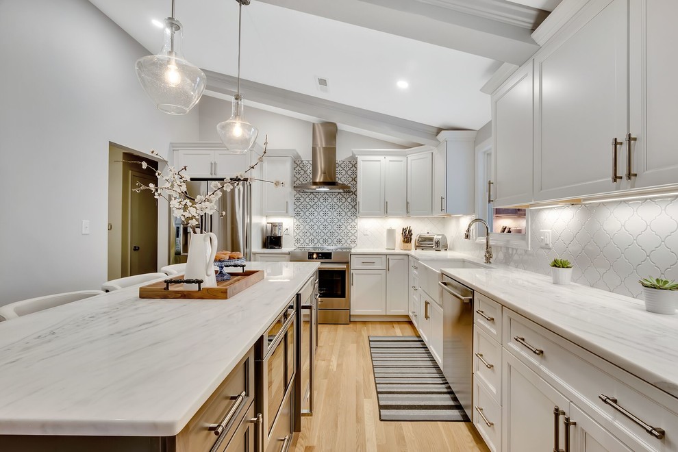 Example of a transitional light wood floor eat-in kitchen design in Boston with an island