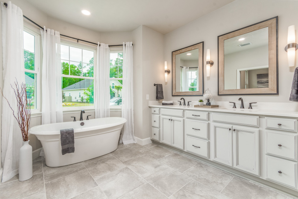 Photo of a mid-sized master bathroom in Other with grey cabinets, a freestanding tub, an alcove shower, a two-piece toilet, white tile, subway tile, beige walls, ceramic floors, an undermount sink, granite benchtops, grey floor, a hinged shower door, white benchtops, a shower seat, a double vanity and a built-in vanity.