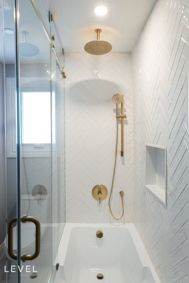 This is an example of a mid-sized traditional master bathroom in Toronto with shaker cabinets, blue cabinets, a corner tub, a one-piece toilet, white tile, porcelain tile, blue walls, porcelain floors, an undermount sink, engineered quartz benchtops, white floor, a hinged shower door, white benchtops, a niche, a single vanity and a freestanding vanity.
