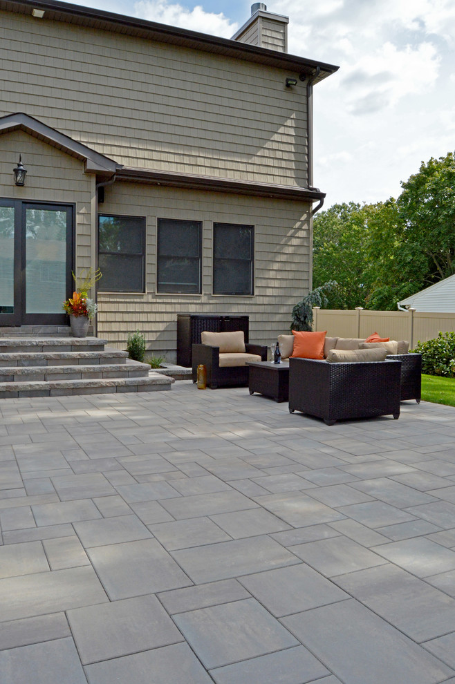 Design ideas for a transitional backyard patio in New York with a fire feature and concrete pavers.
