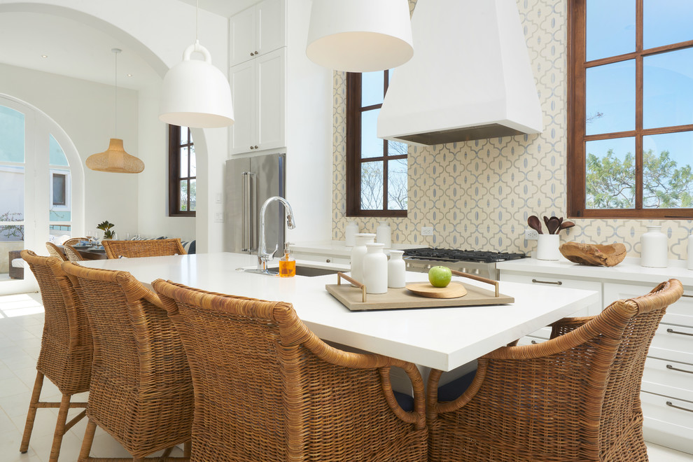 This is an example of a mid-sized beach style galley eat-in kitchen in Other with an undermount sink, shaker cabinets, white cabinets, quartz benchtops, multi-coloured splashback, cement tile splashback, stainless steel appliances, cement tiles, with island, white floor and white benchtop.