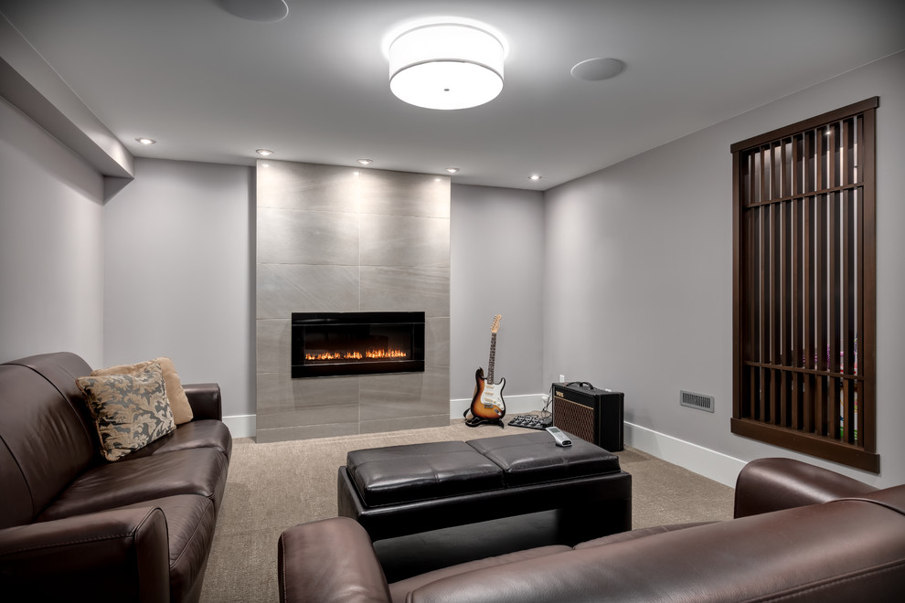 Contemporary basement in Calgary with grey walls, carpet, a standard fireplace and a tile fireplace surround.