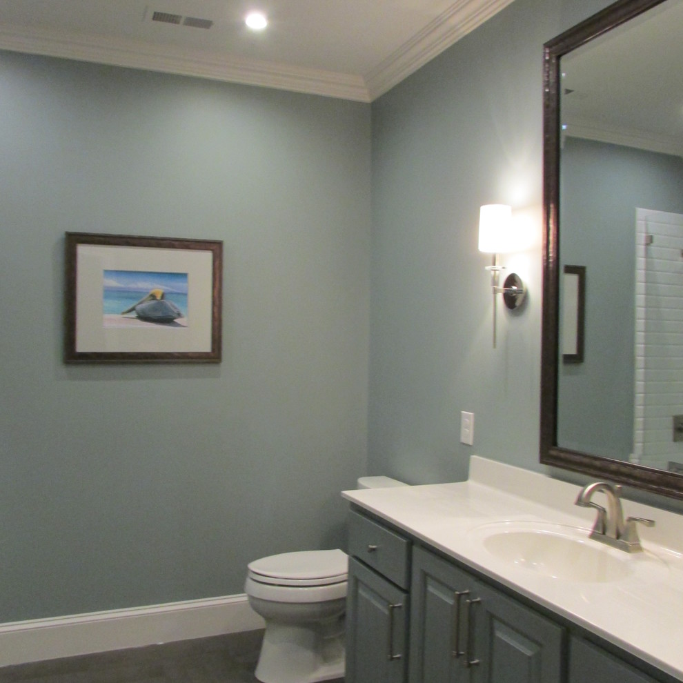 Design ideas for a mid-sized contemporary kids bathroom in Charlotte with a shower/bathtub combo, white tile, subway tile, blue walls, an integrated sink, raised-panel cabinets, blue cabinets, a drop-in tub and a one-piece toilet.