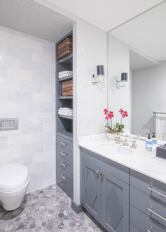 Inredning av ett stort en-suite badrum, med grå skåp, vit kakel, keramikplattor, vita väggar, grått golv och dusch med gångjärnsdörr