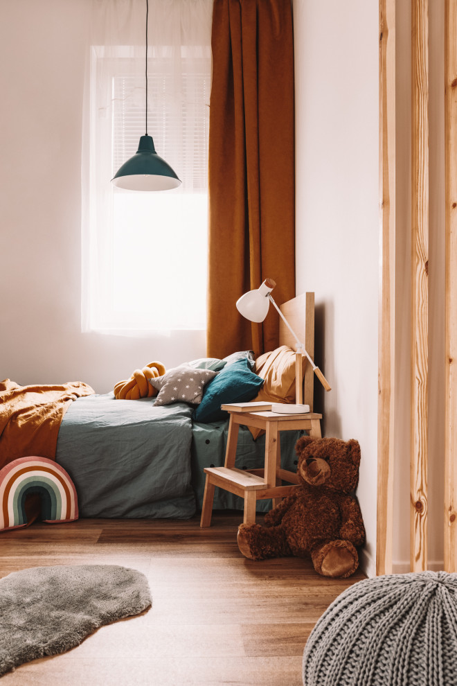 На фото: детская среднего размера в современном стиле с спальным местом, белыми стенами, полом из ламината и разноцветным полом для ребенка от 4 до 10 лет, мальчика