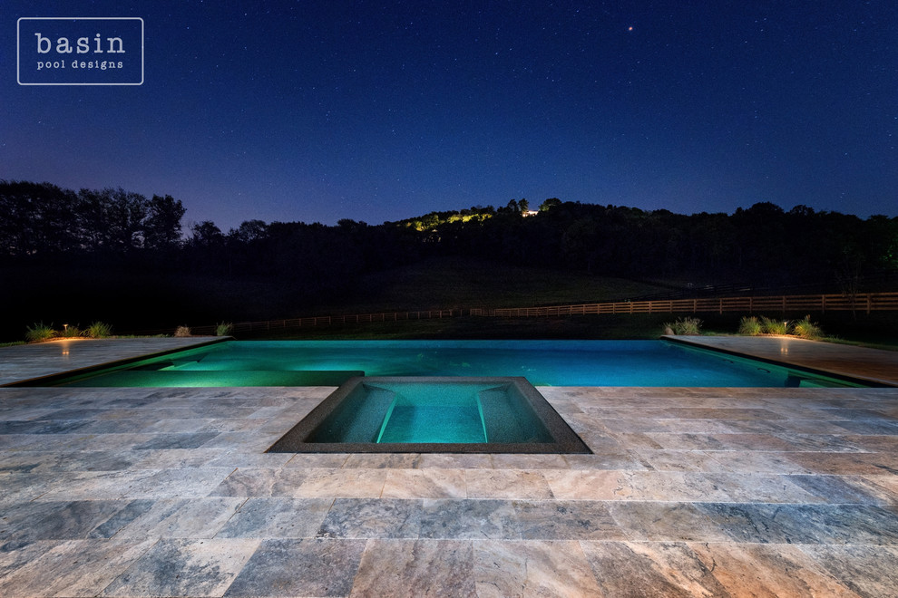 Example of a large transitional backyard stone and custom-shaped infinity hot tub design in Nashville