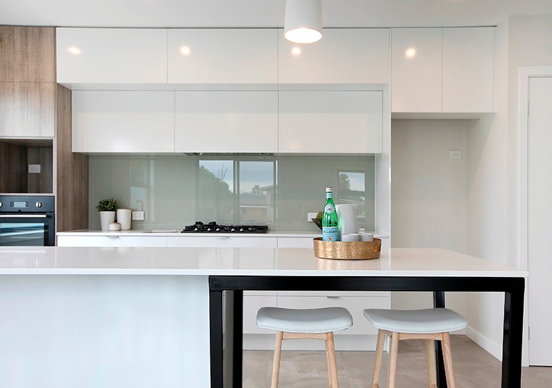 Inspiration for a mid-sized contemporary kitchen in Melbourne with a double-bowl sink, grey splashback, glass sheet splashback, black appliances and porcelain floors.
