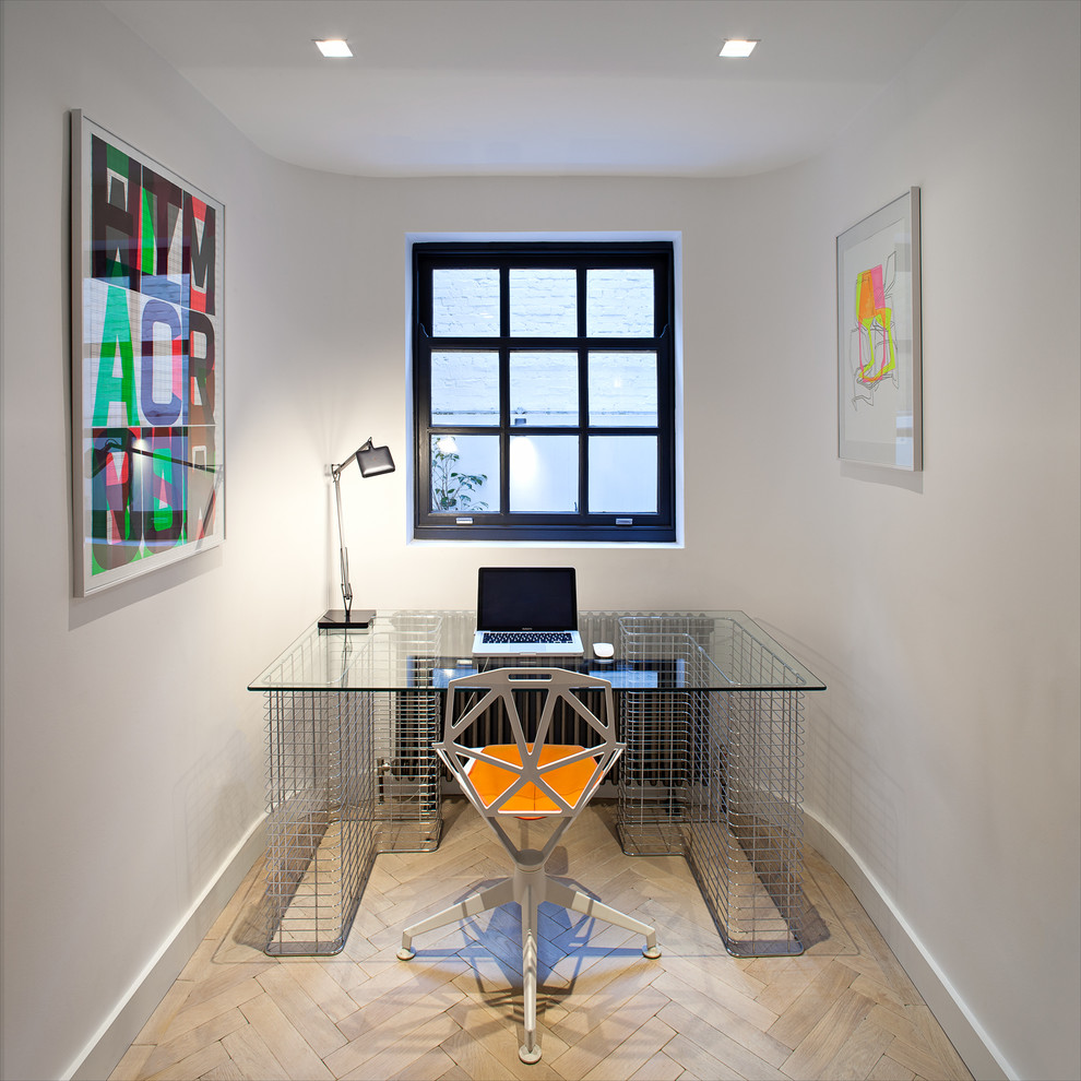 This is an example of a mid-sized contemporary home office in London with white walls and a freestanding desk.