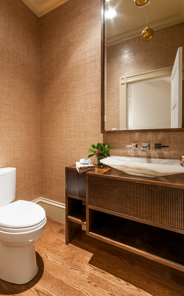 This is an example of a contemporary powder room in Boston with flat-panel cabinets, medium wood cabinets, brown walls, light hardwood floors and a vessel sink.