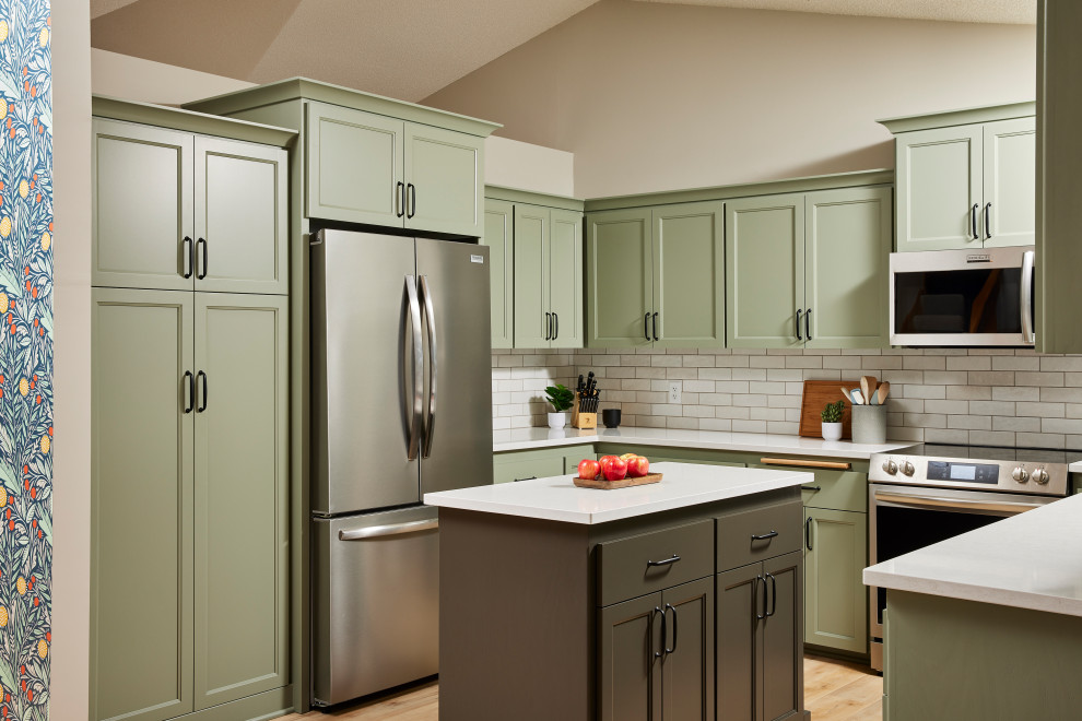 Mid-sized transitional u-shaped vinyl floor and brown floor eat-in kitchen photo in Minneapolis with an undermount sink, shaker cabinets, green cabinets, quartz countertops, white backsplash, ceramic backsplash, stainless steel appliances, an island and white countertops