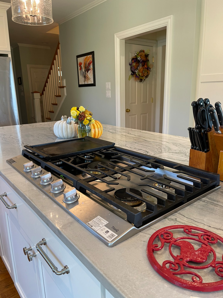 Inspiration for a large transitional light wood floor and brown floor eat-in kitchen remodel with an undermount sink, shaker cabinets, white cabinets, quartzite countertops, green backsplash, marble backsplash, stainless steel appliances, an island and gray countertops