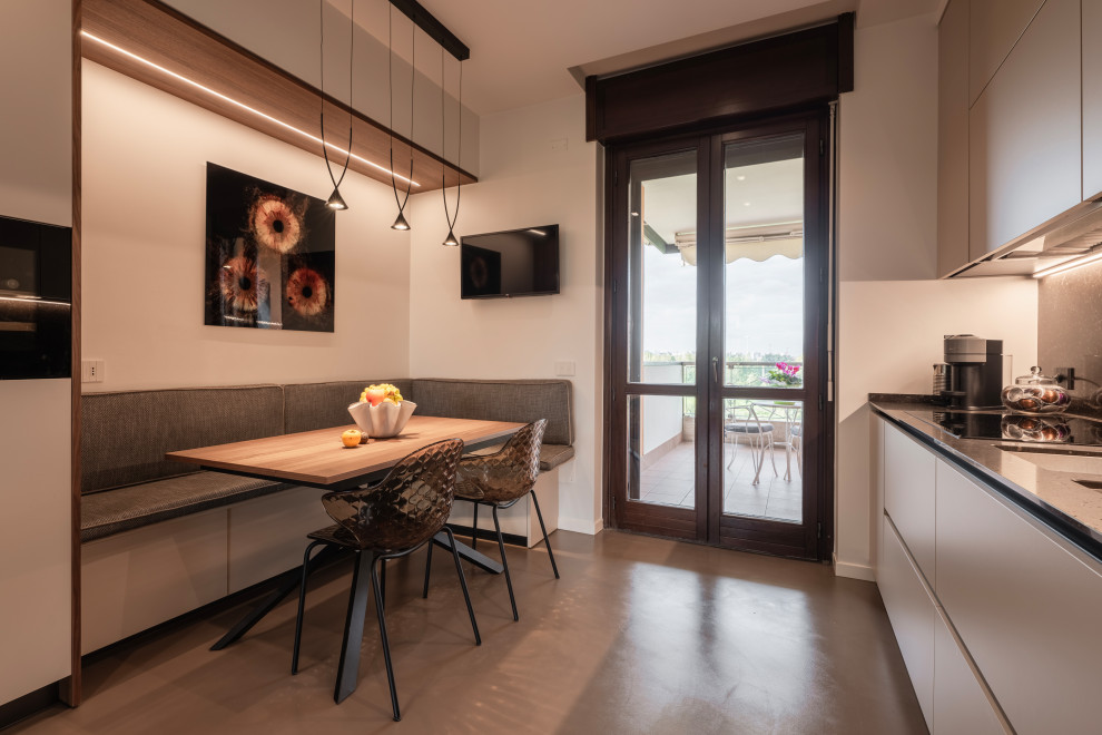 Photo of a large modern galley enclosed kitchen in Milan with a double-bowl sink, flat-panel cabinets, beige cabinets, composite countertops, brown splashback, porcelain splashback, black appliances, dark hardwood flooring, no island, brown floors, brown worktops and a drop ceiling.