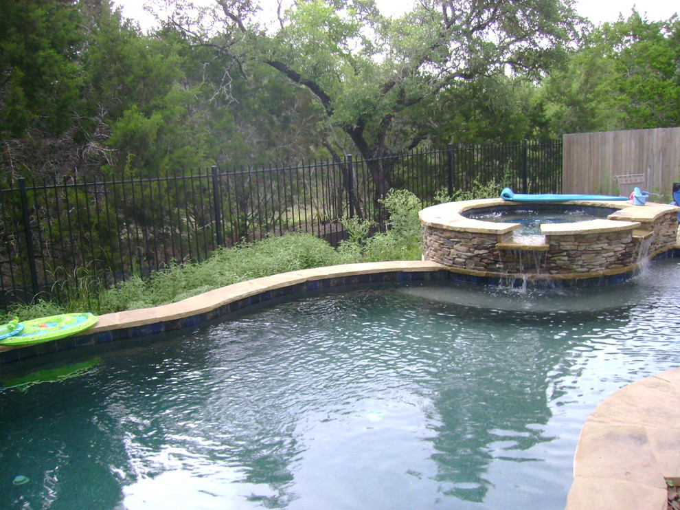 Example of a mid-sized transitional backyard stone and custom-shaped lap hot tub design in Austin