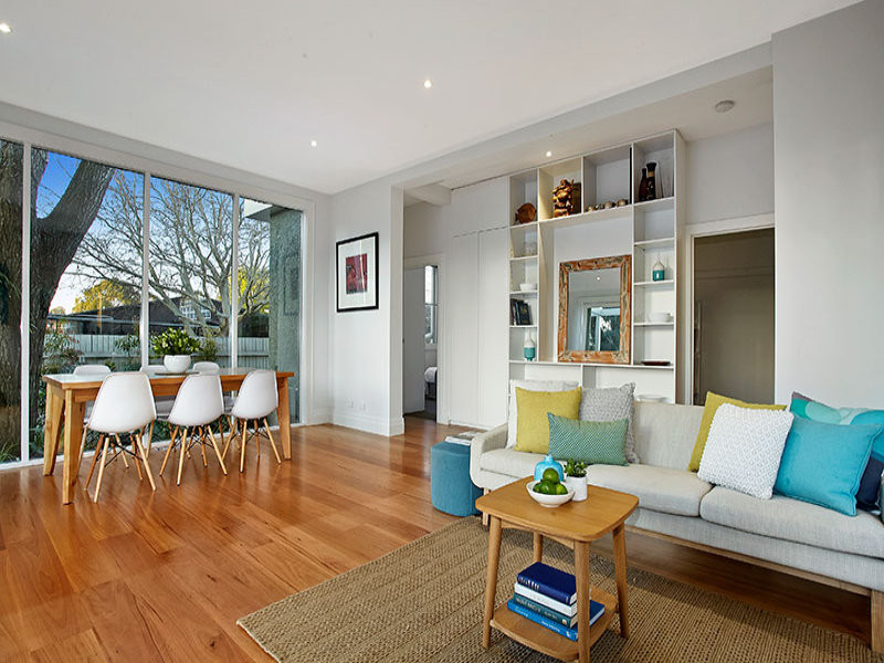 This is an example of a small contemporary open concept family room in Melbourne with white walls and medium hardwood floors.