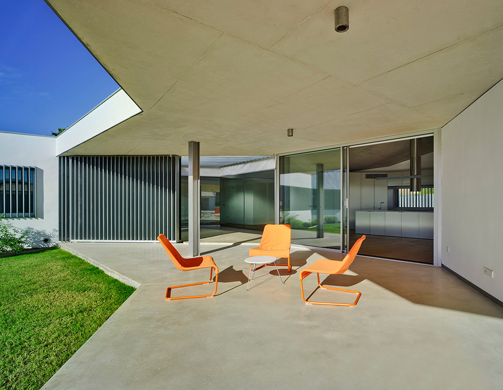 Ejemplo de terraza actual de tamaño medio en patio trasero y anexo de casas