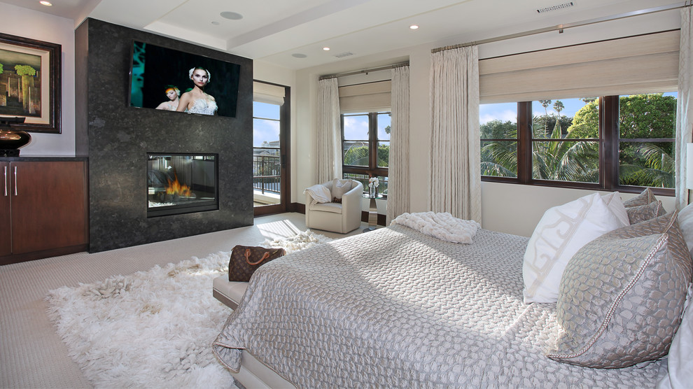 Inspiration for a large contemporary master carpeted bedroom remodel in Orange County with white walls, a standard fireplace and a stone fireplace