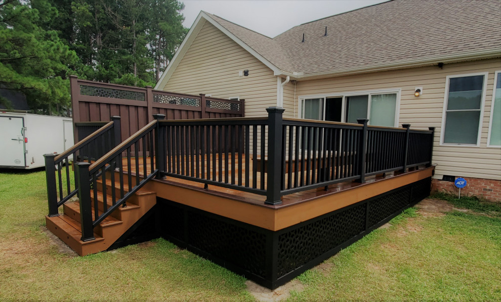 Inspiration for a mid-sized contemporary backyard and ground level deck in Raleigh with with skirting, no cover and mixed railing.