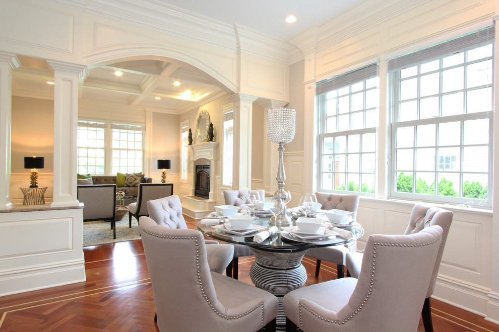 This is an example of a small modern dining room in New York with white walls and medium hardwood floors.