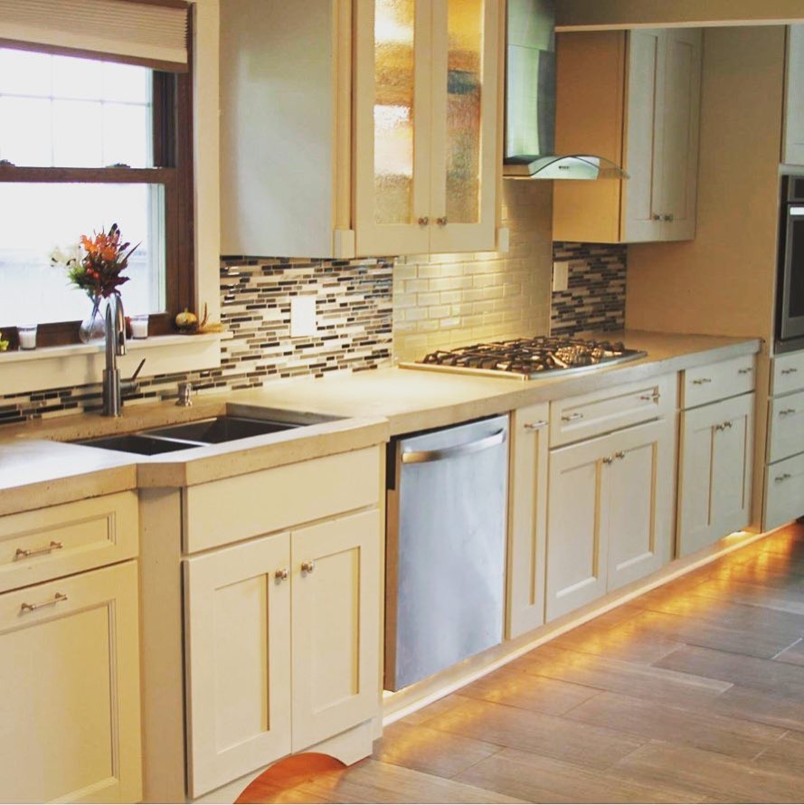 Inspiration for a mid-sized transitional galley medium tone wood floor and beige floor open concept kitchen remodel with a double-bowl sink, recessed-panel cabinets, white cabinets, quartz countertops, multicolored backsplash, matchstick tile backsplash, stainless steel appliances, an island and beige countertops