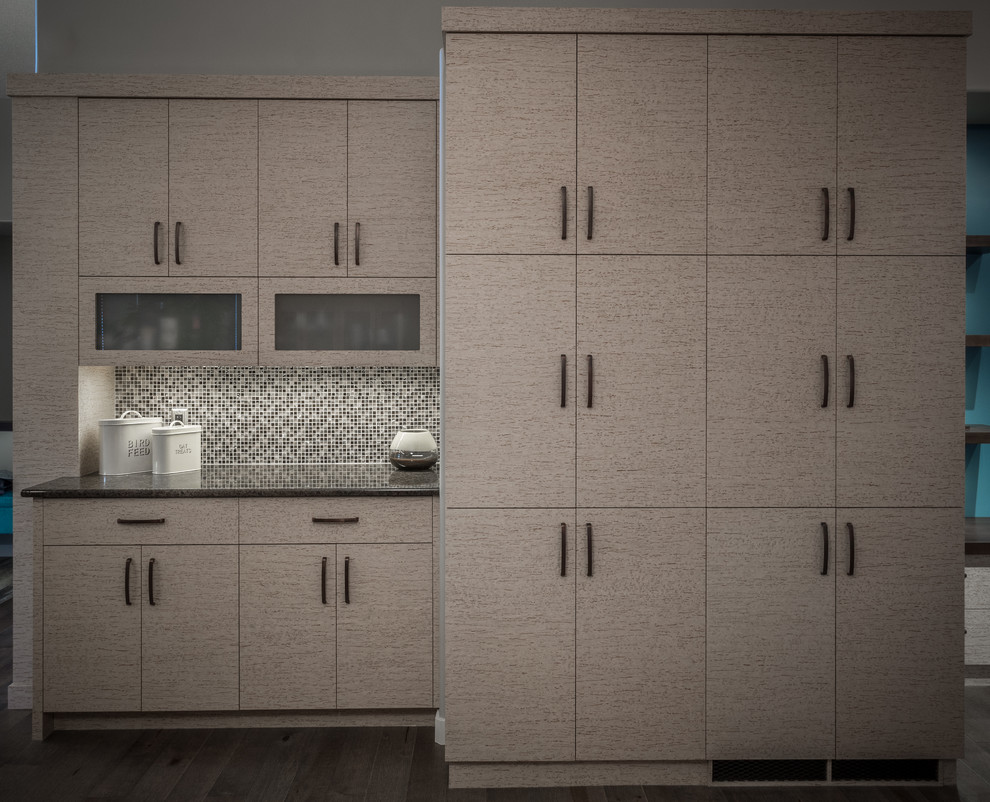 Example of a mid-sized minimalist u-shaped medium tone wood floor and gray floor enclosed kitchen design with a double-bowl sink, flat-panel cabinets, beige cabinets, granite countertops, multicolored backsplash, mosaic tile backsplash, stainless steel appliances and a peninsula