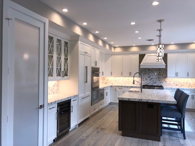 Large transitional l-shaped open concept kitchen photo with a farmhouse sink, quartz countertops, stainless steel appliances and an island
