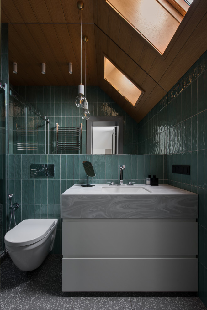 Small contemporary ensuite bathroom in Moscow with flat-panel cabinets, white cabinets, an alcove shower, a wall mounted toilet, green tiles, ceramic tiles, green walls, porcelain flooring, a submerged sink, solid surface worktops, grey floors, a sliding door, grey worktops, an enclosed toilet, a single sink, a freestanding vanity unit and a wood ceiling.