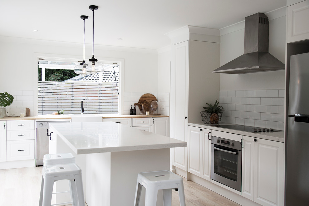 Design ideas for a contemporary l-shaped open plan kitchen in Sydney with quartz benchtops, an undermount sink, raised-panel cabinets, white cabinets, white splashback, porcelain splashback, stainless steel appliances, plywood floors and with island.