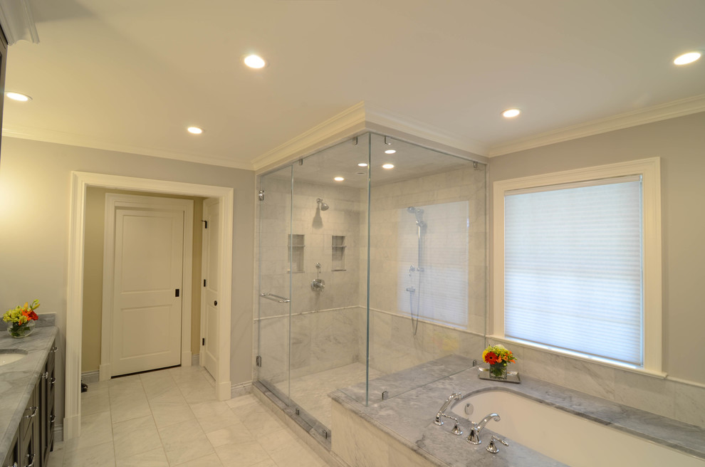 Mid-sized contemporary master bathroom in New York with shaker cabinets, black cabinets, an undermount tub, a corner shower, a two-piece toilet, stone tile, grey walls, marble floors, an undermount sink, marble benchtops, grey floor and a hinged shower door.