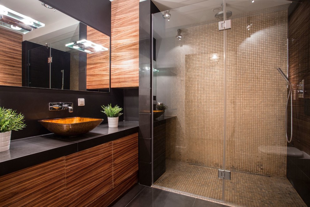 Photo of a modern bathroom in Miami with flat-panel cabinets, dark wood cabinets, a curbless shower, black walls, porcelain floors, a vessel sink, concrete benchtops, black floor and a hinged shower door.