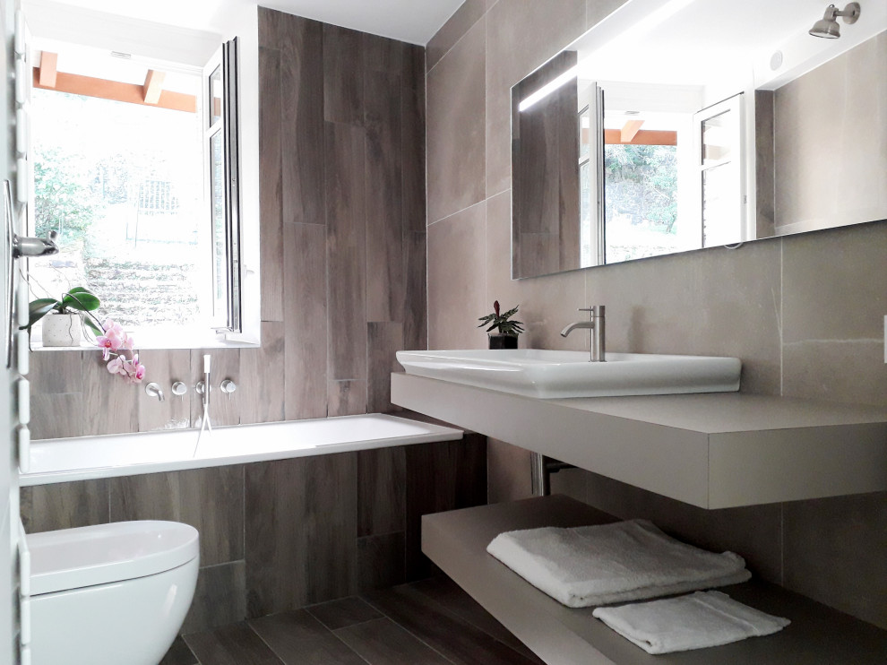 Design ideas for a small contemporary family bathroom in Grenoble with brown cabinets, a submerged bath, a wall mounted toilet, brown tiles, wood-effect tiles, wood-effect flooring, a trough sink, laminate worktops, brown floors, brown worktops, a single sink and a built in vanity unit.